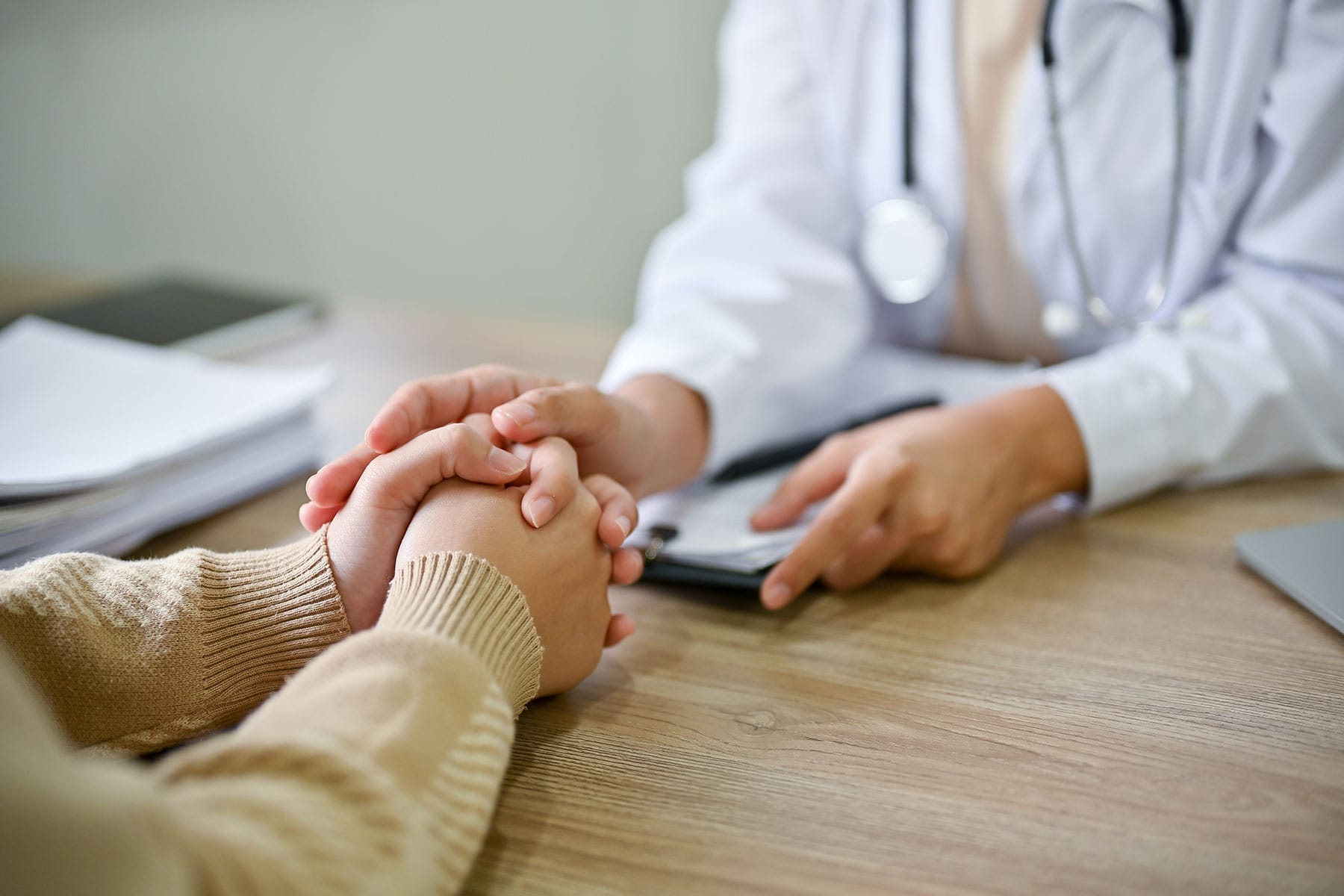 Woman holds hands together while talking to doctor about common eating disorders